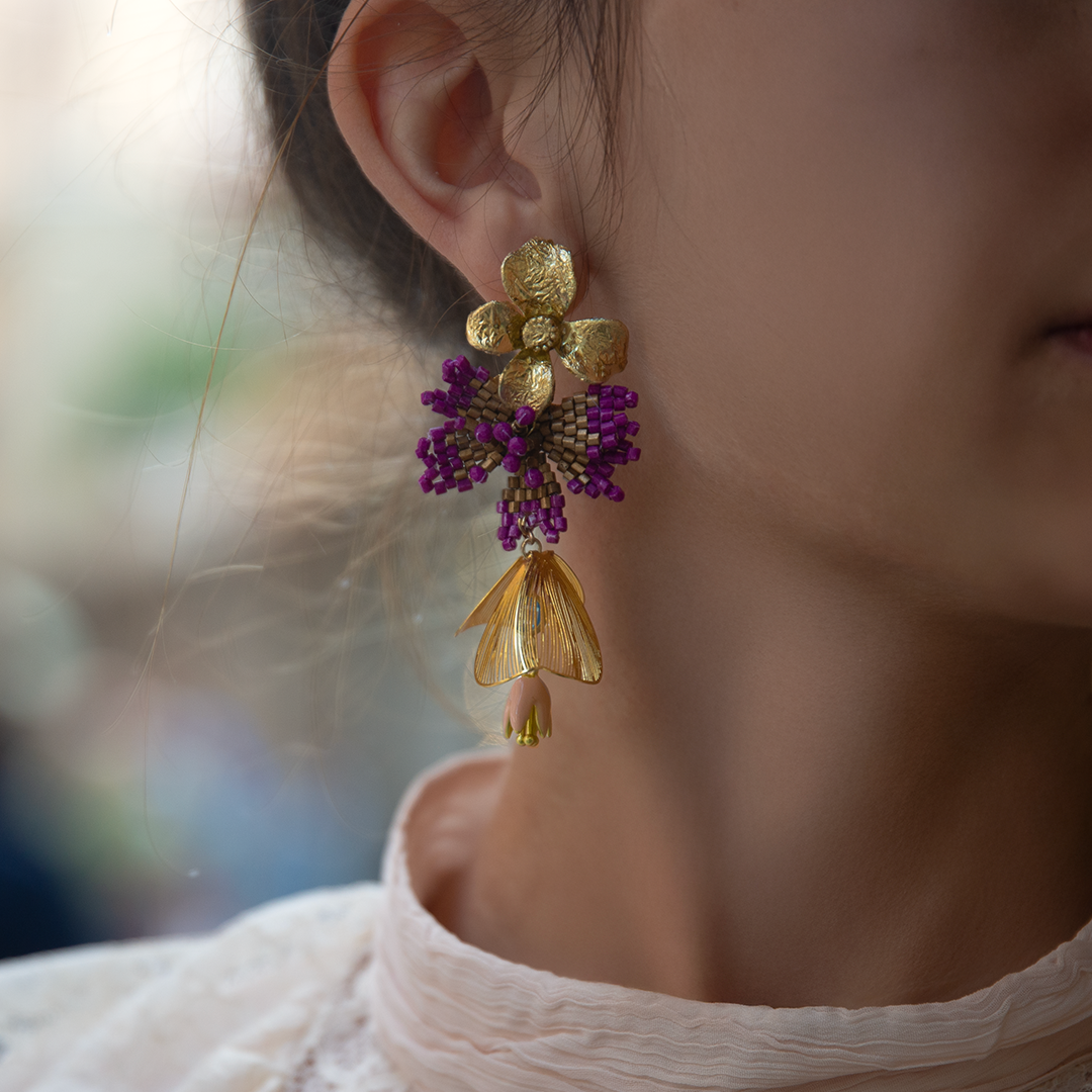Earrings in gold leaf, woven beads, steel, opal, and preserved flower | Nuna Qori